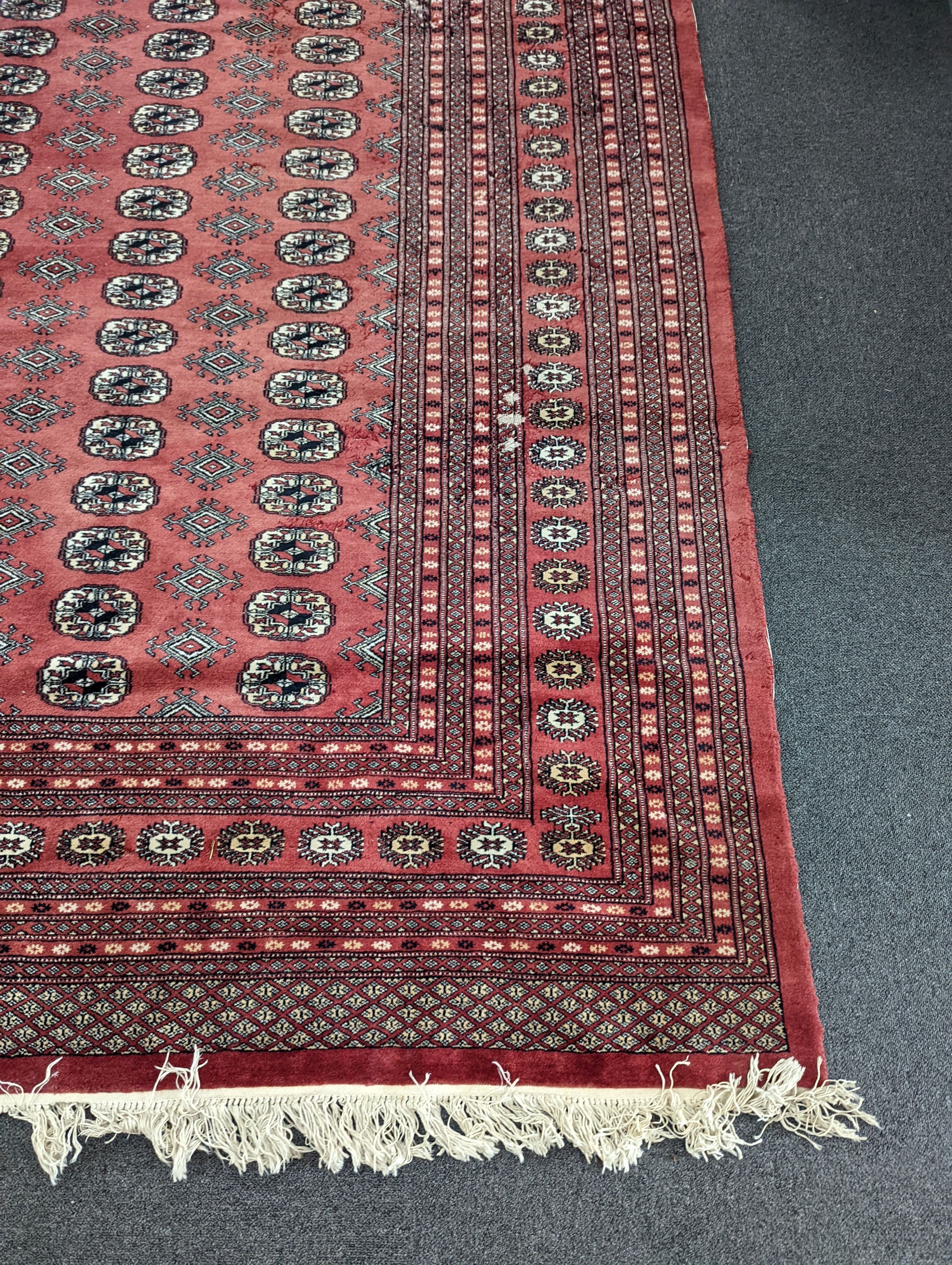 A Bokhara burgundy ground carpet, 360 x 276cm